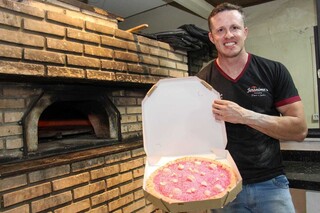 Proprietário da pizzaria, Rogero segura criação especial para Boneca. (Foto: Juliano Almeida)
