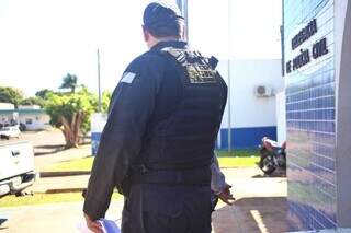 De moletom cinza, servidor se esconde atrás de policial do Gaeco. (Foto: Paulo Francis)