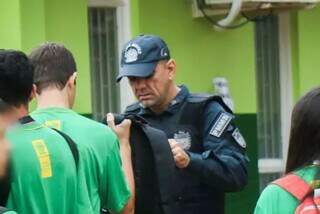 Policial militar vistoria mochila de aluno em escola estadual de MS (Foto: Henrique Kawaminami/Arquivo)