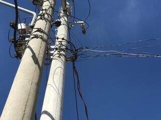 Poste de energia com vários fios amontoados, indicando irregularidade (Foto: Arquivo/ Campo Grande News)