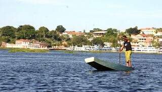 Morador navega no Rio Paraguai: no fundo a cidade de Corumbá, capital do Pantanal.