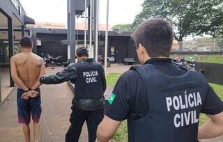 Um dos presos em Dourados é conduzido por policiais civis (Foto: Adilson Domingos)