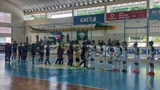 Time da Escola Pelezinho, de branco, perfilado antes de jogo pela competição (Foto: Divulgação/Pelezinho)