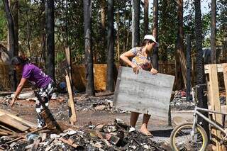 M&atilde;es que perderam casas em inc&ecirc;ndio retornam para limpar e reconstruir barracos