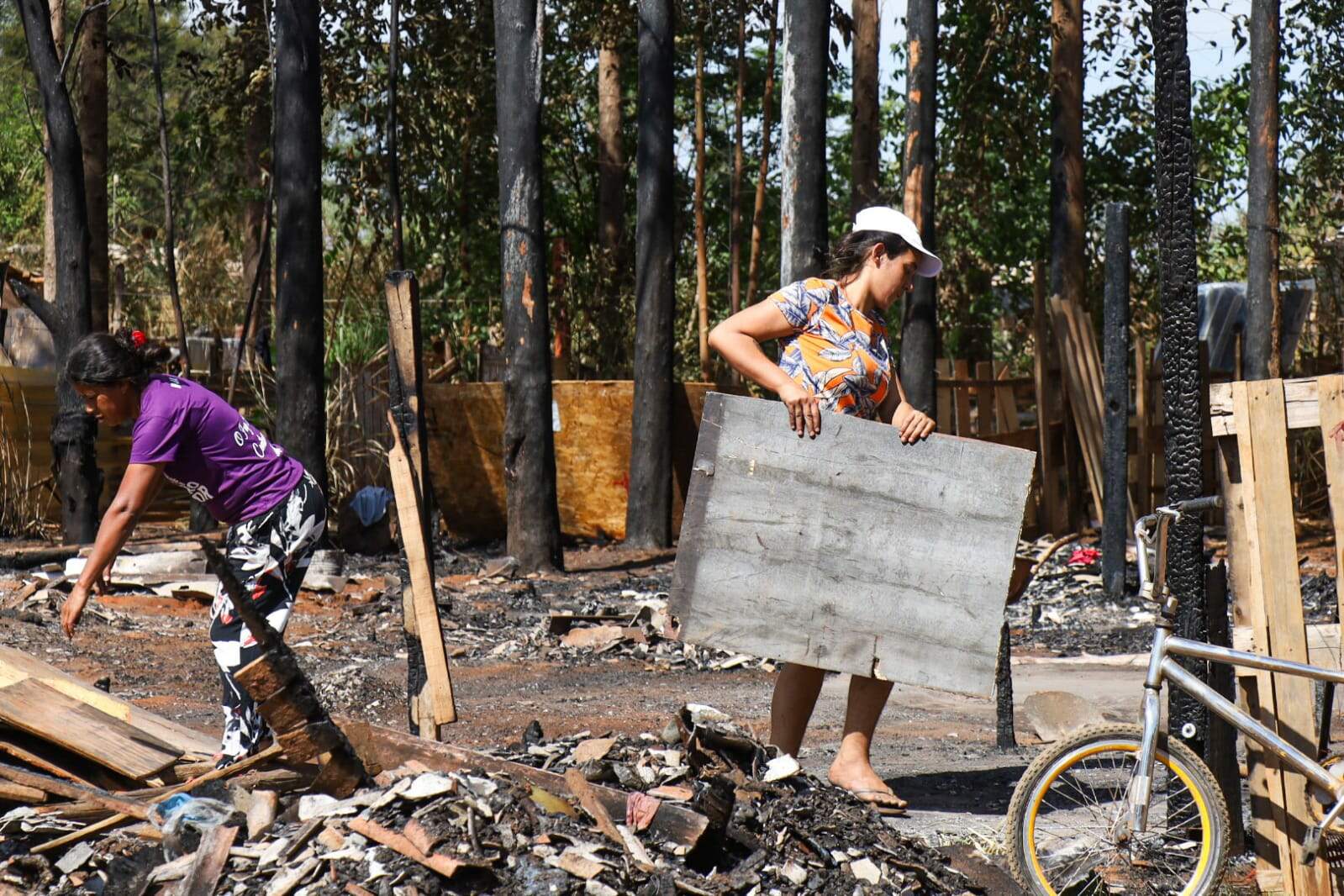 Mães que perderam casas em incêndio retornam para limpar e reconstruir barracos