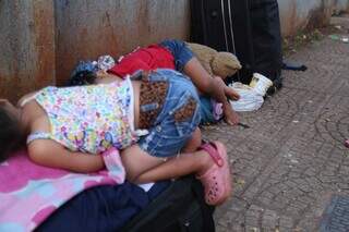 Duas crianças venezuelanas dormem em malas, em frente ao Cedami, em Campo Grande (Foto: Alex Machado)