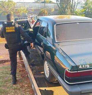 Agente da PF ao lado de Opala, um dos carros apreendidos hoje (Foto: Divulgação)