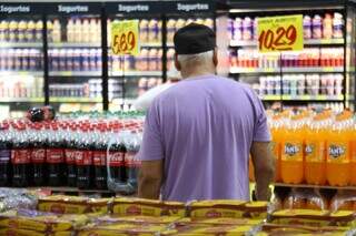 Cliente avalia preços em supermercado, em Campo Grande (Foto: Alex Machado)