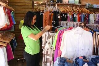 Vendedora organiza roupas em loja, no Centro de Campo Grande (Foto: Paulo Francis)