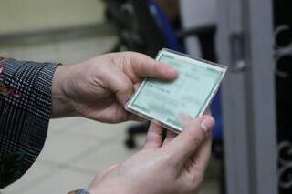 Cidadã sul-mato-grossense segura documento de identificação (Foto: Paulo Francis)