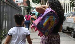 Estundante com responsável a caminho da escola (Foto: Tânia Rêgo)