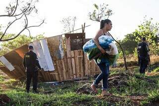 Aos prantos, moradora leva pertences após ter barraco demolido pela GCM (Foto: Henrique Kawaminami)