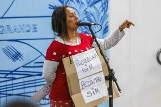 Protetora de animais Lígida Santos vestiu roupas rasgadas e pendurou no pescoço um cartaz (Foto: Henrique Kawaminami)