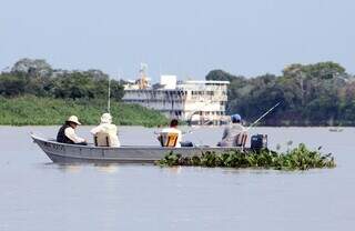 Quatro pescadores, sossegados, esperam o peixe engoliar a isca no Rio Paraguai. (Foto: Divulgação)