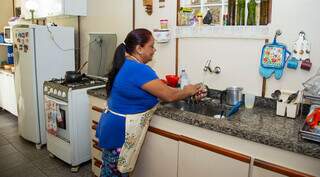 Mulheres se dedicam em média 19,2 horas por semana aos afazeres domésticos; na foto, mulher lava a louça (Foto: Reprodução/IBGE)