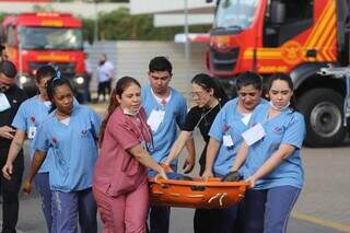 Funcionários fazendo o transporte de vítima durante a simulação (Foto: Lucas Santana)