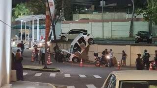 Veículo branco despencou de estacionamento na Avenida Ernesto Geisel, em Campo Grande. (Foto: Direto das Ruas)