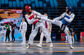 Atletas disputando combate de taekwondo. (Foto: Guilherme Taboada)