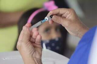 Profissional de saúde preparando a dose do imunológico para aplicar em criança (Foto: Marcos Maluf)