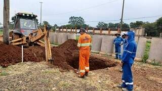 Funcionários trabalhando com escavadeira às margens da Avenida Duque de Caxias na manhã desta segunda-feira (14). (Foto: Marcos Maluf)