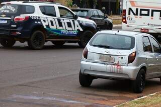 Celta com sangue e viatura da Polícia Militar no local da ocorrência. (Foto: Henrique Kawaminami)