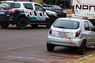 Celta com sangue e viatura da Polícia Militar no local da ocorrência. (Foto: Henrique Kawaminami)