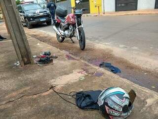 Motocicleta, capacete e par tênis ao lado de marcas de sangue da vítima  (Foto: Geniffer Valeriano) 