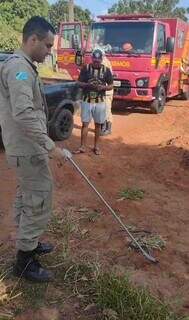 Militar do Corpo de Bombeiros retirou a cobra da picape e soltou em mata próxima ao local (Foto: Direto das Ruas)