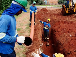 Trabalhadores instalam tubulação de esgoto em rua de Campo Grande. (Foto: Arquivo)