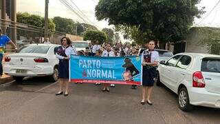 Participantes da passeata carregam um dos cartazes de conscientização (Foto: Divulgação)