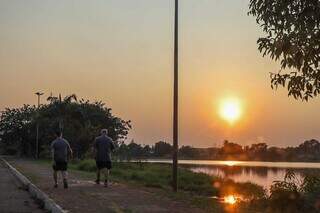 Homens caminhando na Lagoa Itatiaia, em Campo Grande (Foto: Henrique Kawaminami)