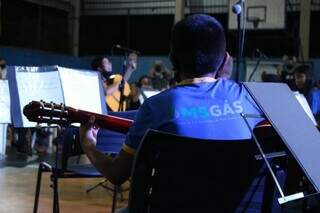 Aluno de projeto social toca vioão durante apresentação. (Foto: Reprodução/MSGás)