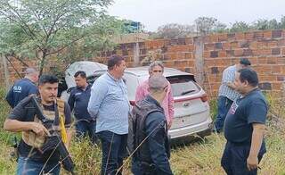 Policiais brasileiros e paraguaios ao lado de Sportage encontrado em terreno baldio (Foto: Divulgação)