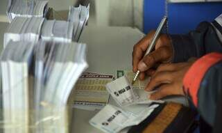 Apostador preenche volante de apostas em agência lotérica. (Foto: Marcello Casal Jr./Agência Brasil)