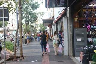 Consumidores segurando sacola, na Rua 14 de Julho (Foto: Paulo Francis)