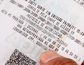 Consumidor mostra dezenas do programa Nota Premiada. (Foto: Arquivo/Campo Grande News)