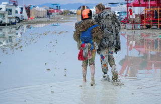 Dupla caminha sobre lama em acampamento no Deserto de Black Rock. (Foto: Trevor Hughes/Reuters)