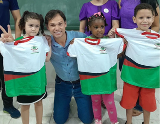 Prefeito Maycol Queiroz (PSDB) posando para fotos com alunos da rede municipal de ensino durante entrega de uniformes (Foto: Instagram)