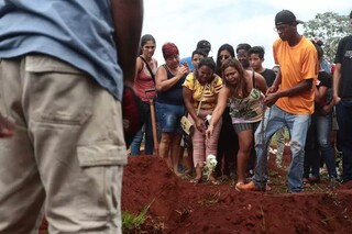 Flores são jogadas sobre o caixão de &#34;Estrelinha&#34;, como era conhecida criança estuprada e morta em bairro de Campo Grande (Foto: Marcos Maluf/Arquivo)