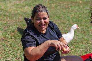 Evelyn dando comida aos patos, no Parque das Nações Indígenas (Foto: Henrique Kawaminami)