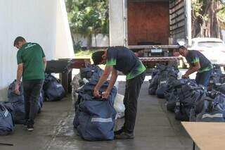 Funcionários descarregam sacolas com os kits esportivos (Foto: Marcos Maluf)