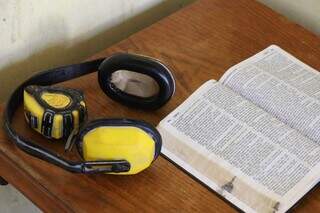 Equipamentos que Celso usava em seu trabalho como marceneiro ao lado de uma bíblia, na estante da casa da viúva. (Foto: Henrique Kawaminami)