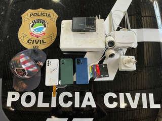 Aparelhos celulares, câmeras e cartões de créditos apreendidos na posse da suspeita. (Foto: Reprodução/Polícia Civil)