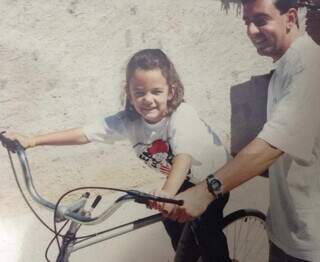 Natália e o tio Carlos, durante uma tentativa de ensinar a menina andar de bicicleta (Foto: Arquivo pessoal)
