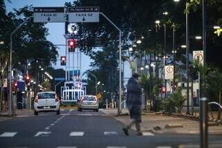 Coberto, homem atravessa trecho da 14 de Julho, no Centro da Capital (Foto: Henrique Kawaminami)