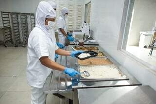 Funcionários no preparo das marmitas congeladas entregues aos trabalhadores (Foto: Divulgação)