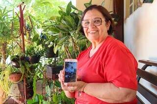 Marlene preserva fotos da amiga, Luzia, em seu celular como parte das memórias. (Foto: Juliano Almeida)
