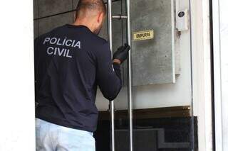 Polícia analisando porta da joalheira assaltada nesta manhã (Foto: Henrique Kawaminami)