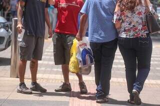 Homem segura sacola com compras feitas, no Centro de Campo Grande (Foto: Marcos Maluf)