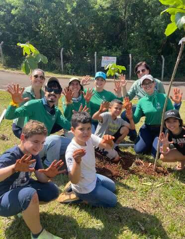 Crian&ccedil;as plantam &aacute;rvores para garantir futuro alimento e casa de araras urbanas